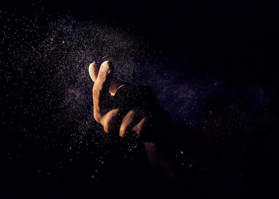 Free Image of A hand with a white powder in the air 