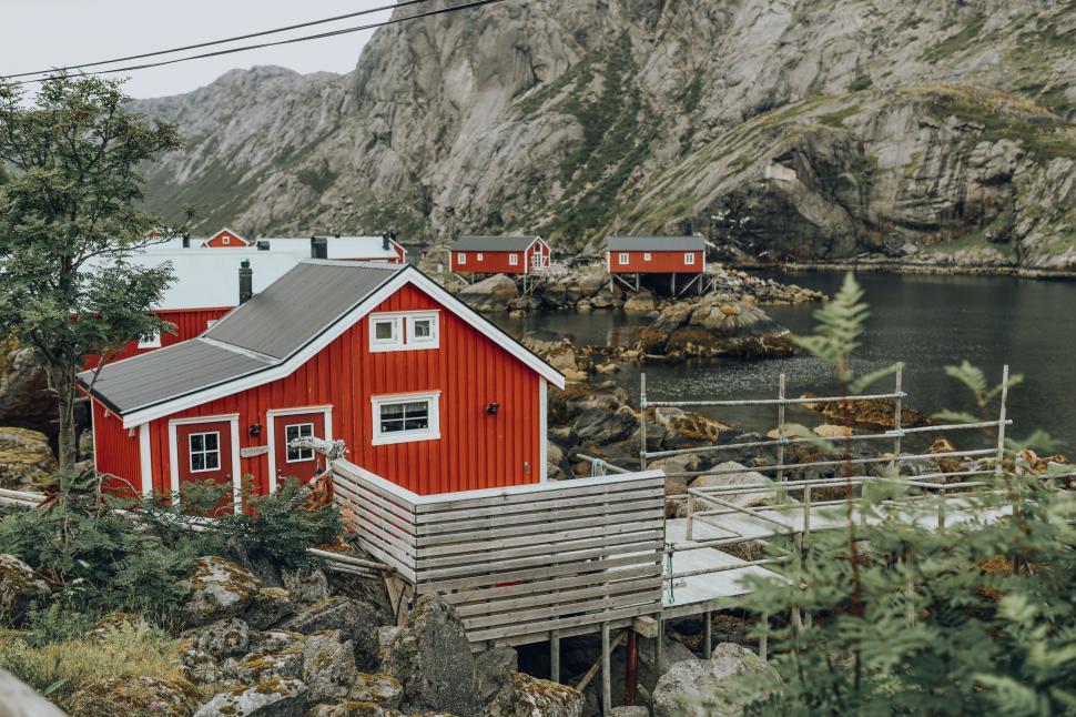 Free Image of A red house next to a body of water 