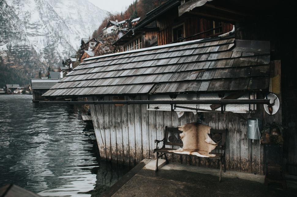 Free Image of A bench on a dock next to a building 