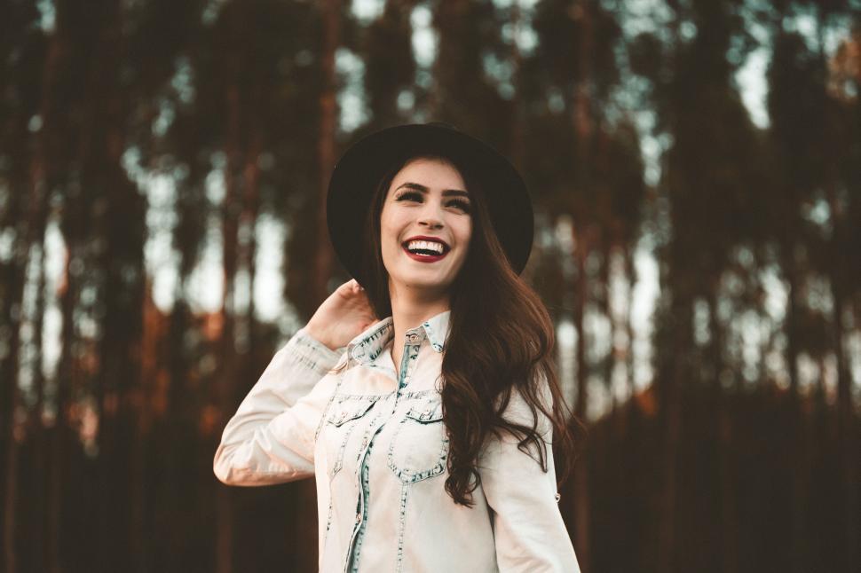 Free Image of A woman smiling with a hat 