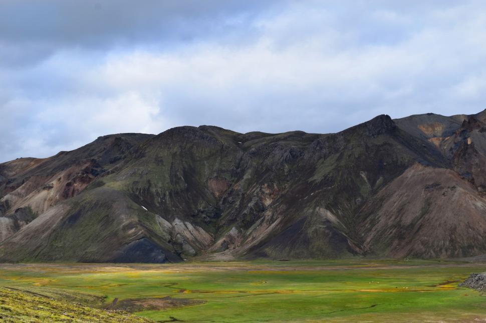 Free Image of A green field with mountains in the background 