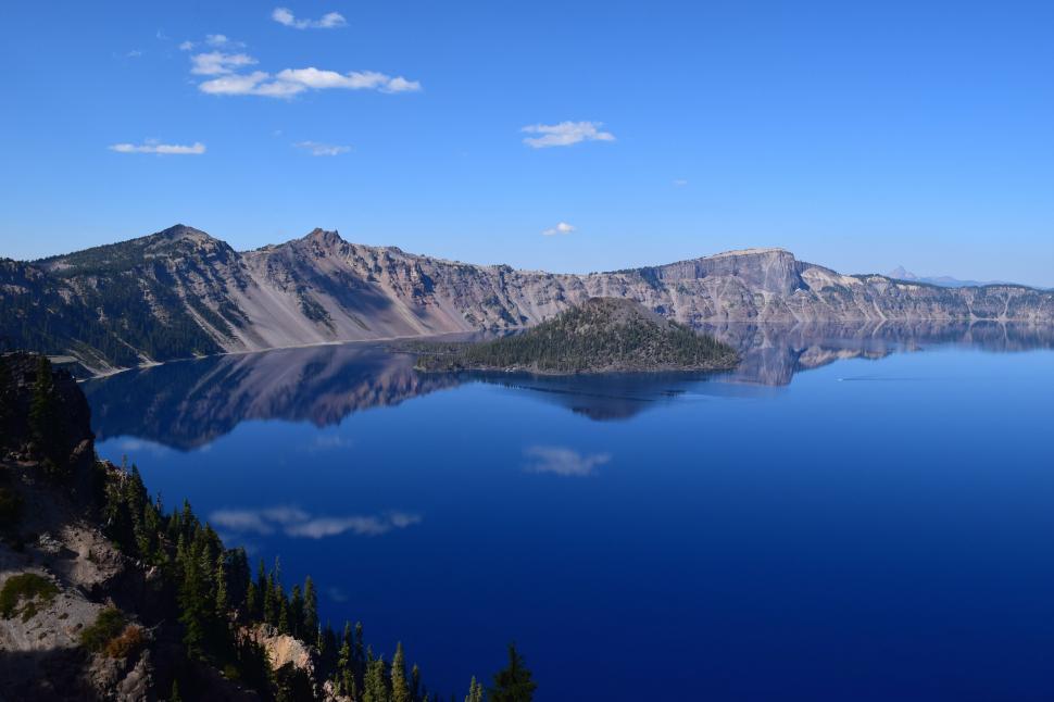 Free Image of A body of water with trees and mountains in the background 