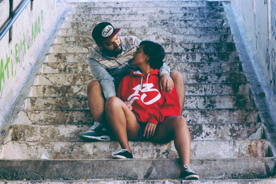 Free Image of A man and woman sitting on stairs 