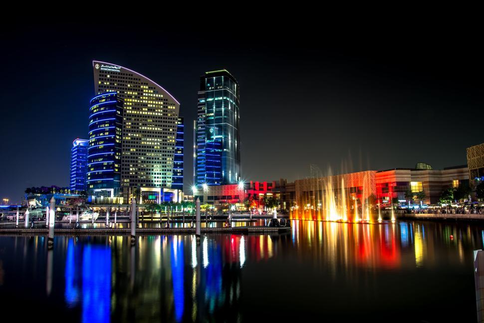 Free Image of A water with a fountain in front of a city at night 