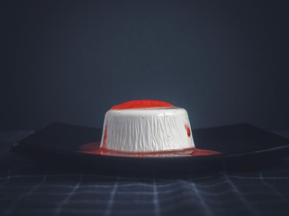 Free Image of A white and red dessert on a black plate 
