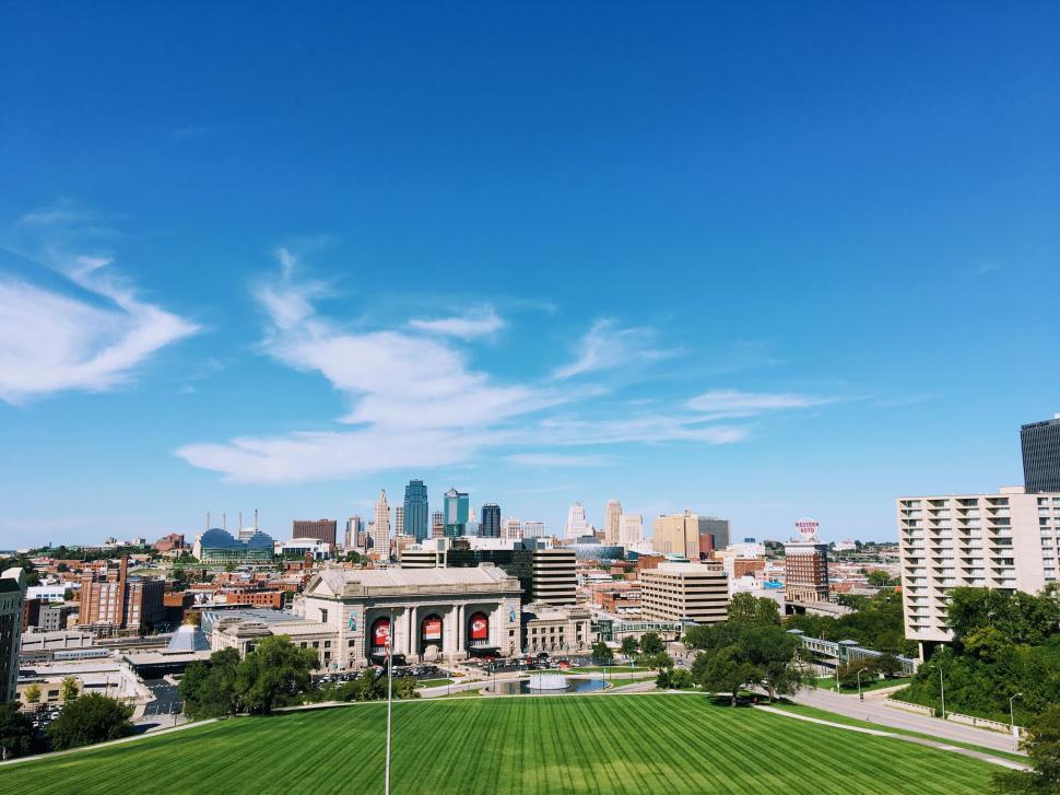 Free Image of A green field with buildings in the background 