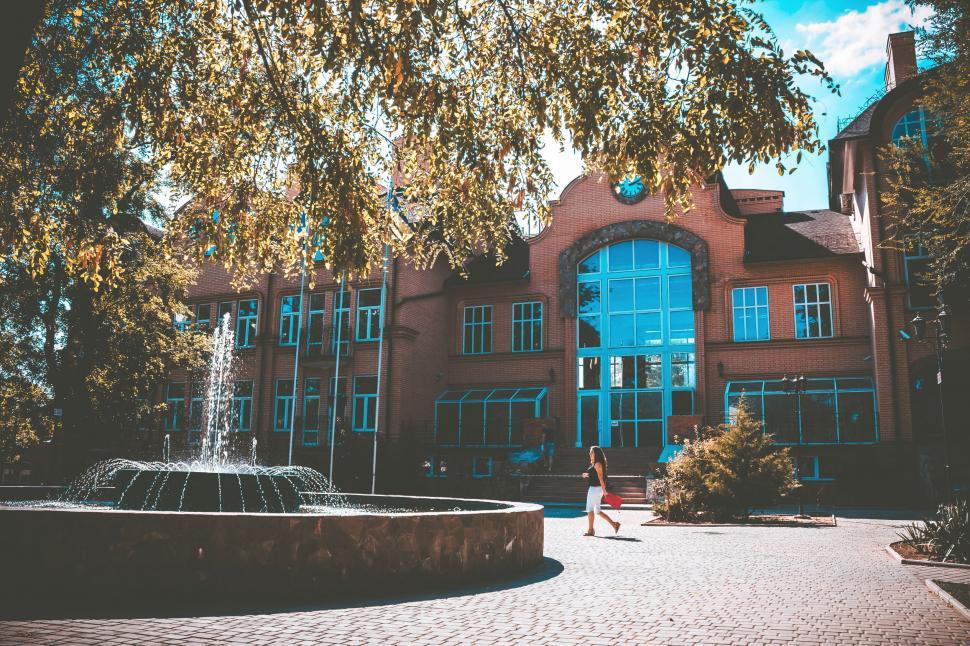 Free Image of A woman walking in front of a building 