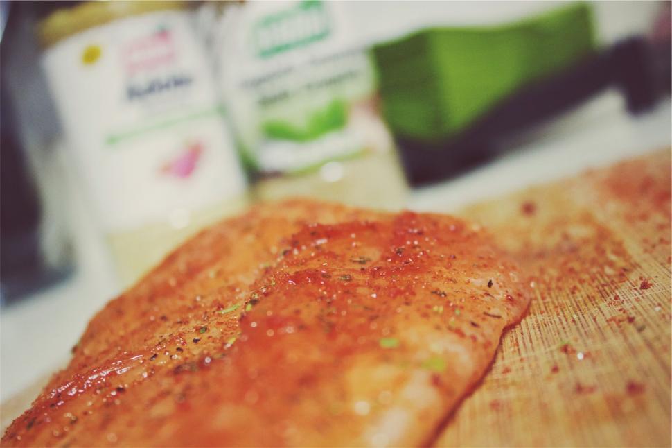 Free Image of A piece of meat with spices on a cutting board 