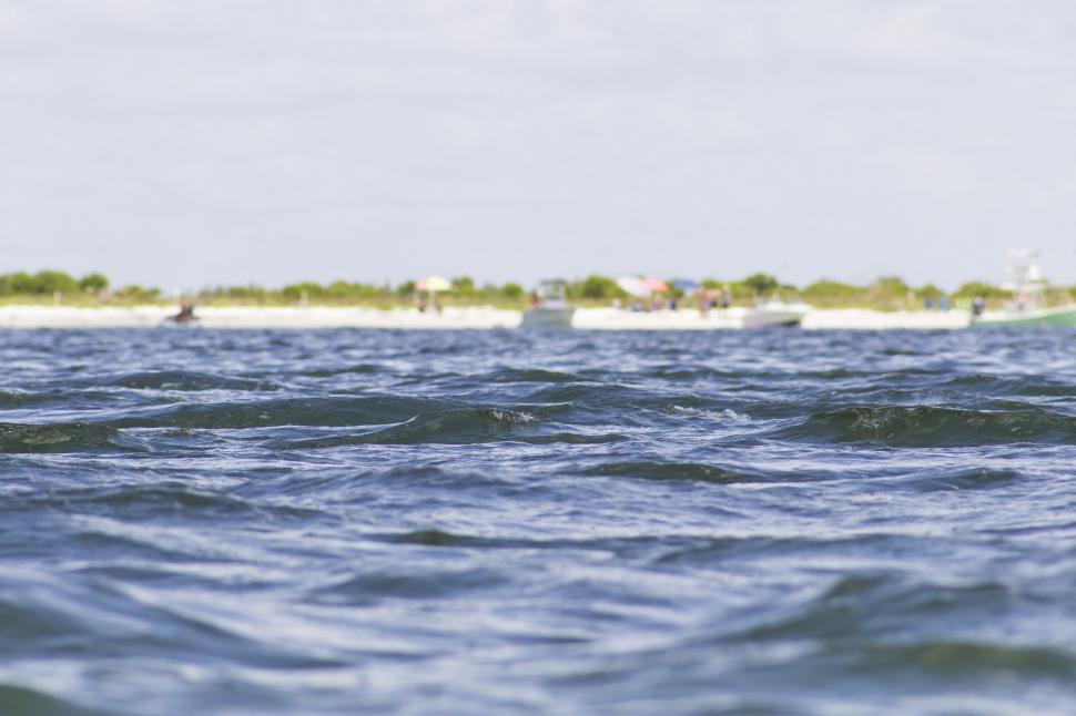 Free Image of A body of water with boats in the background 