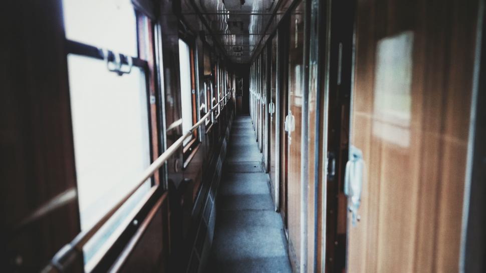 Free Image of A long hallway with doors and windows 