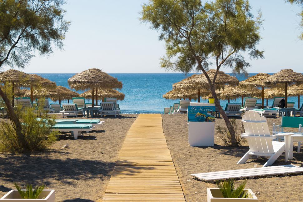 Free Image of A beach with umbrellas and chairs 