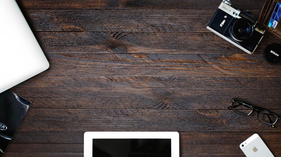 Free Image of A tablet and a camera on a wooden table 