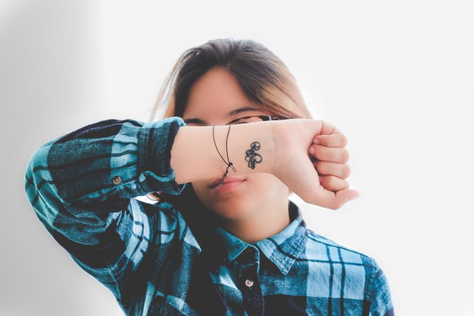 Free Image of A woman covering her face with her hand 