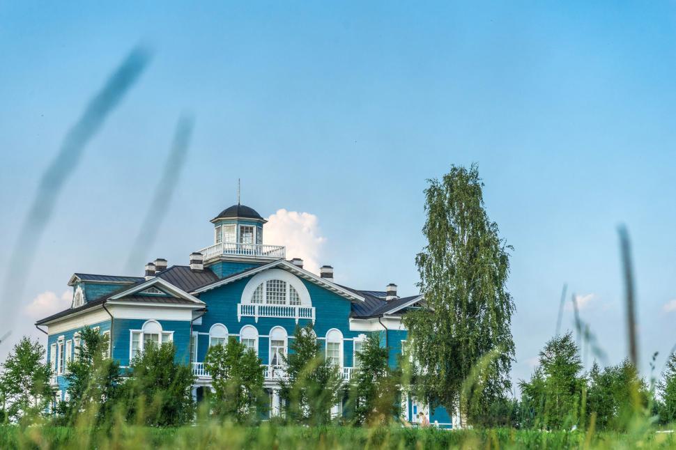 Free Image of A blue and white building with trees in front 
