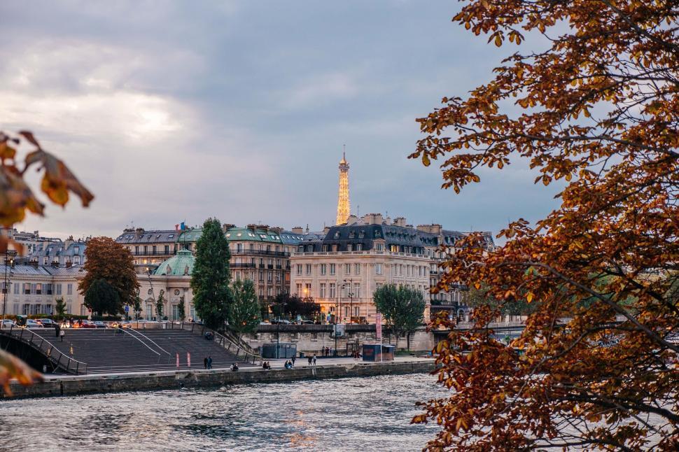 Free Image of A river with trees and buildings in the background 