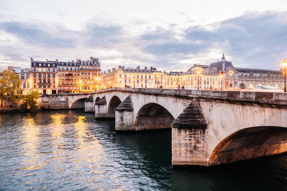 Free Image of A bridge over water with buildings and lights 