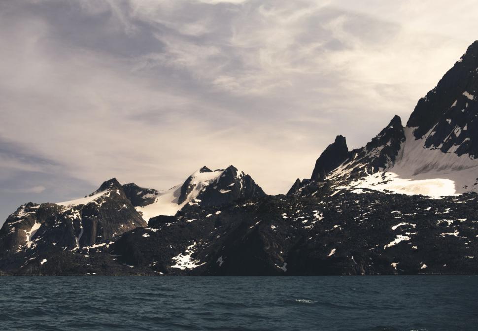 Free Image of A snowy mountain range and water 