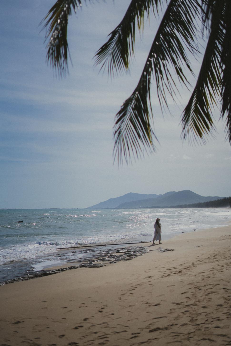 Free Image of A person walking on a beach 