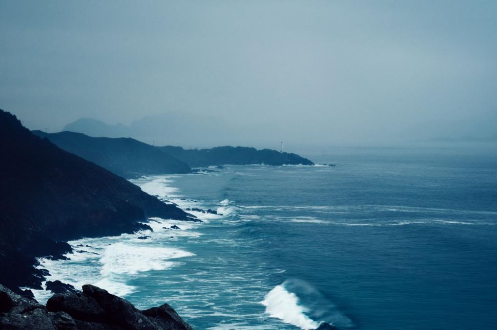 Free Image of A rocky coast with waves crashing on the shore 