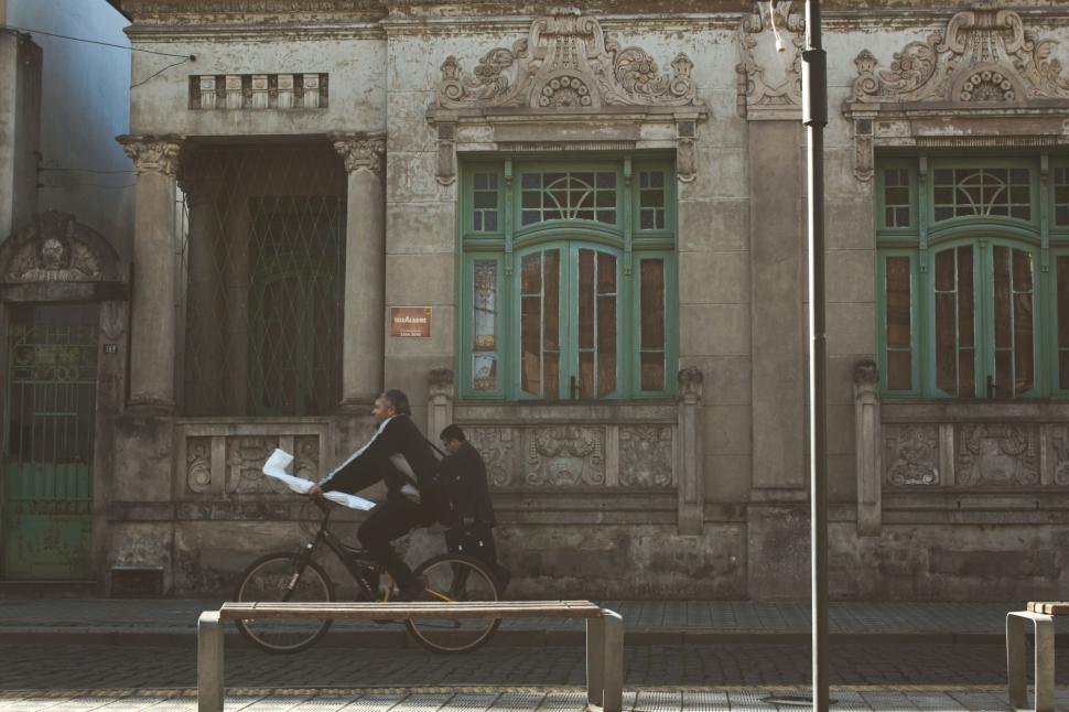 Free Image of A man riding a bicycle on a sidewalk 