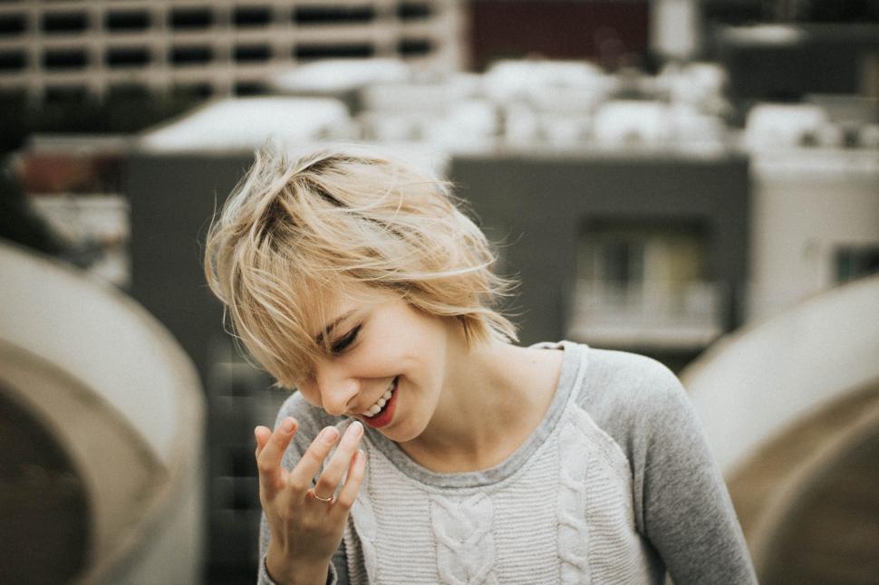 Free Image of A woman smiling with her hand up to her face 
