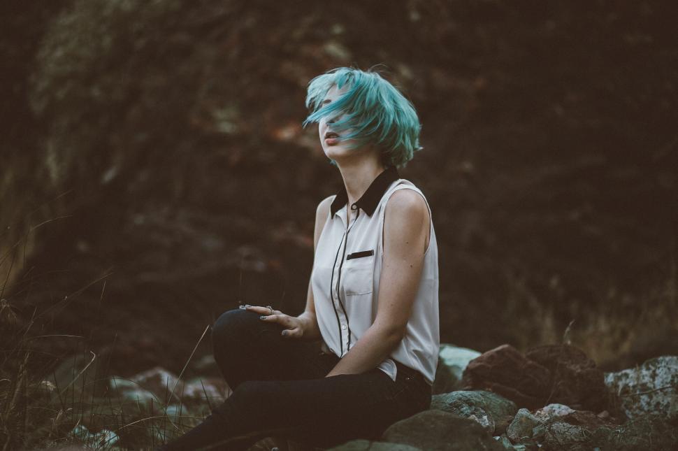 Free Image of A woman sitting on rocks 
