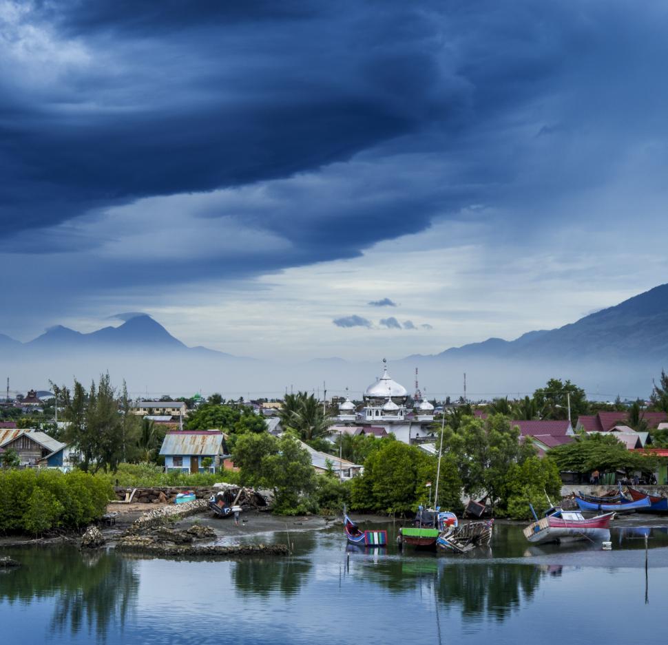 Free Image of A body of water with boats and mountains in the background 