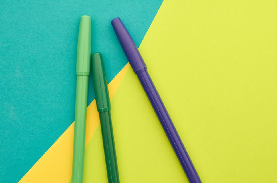 Free Image of A group of markers on a yellow and green background 
