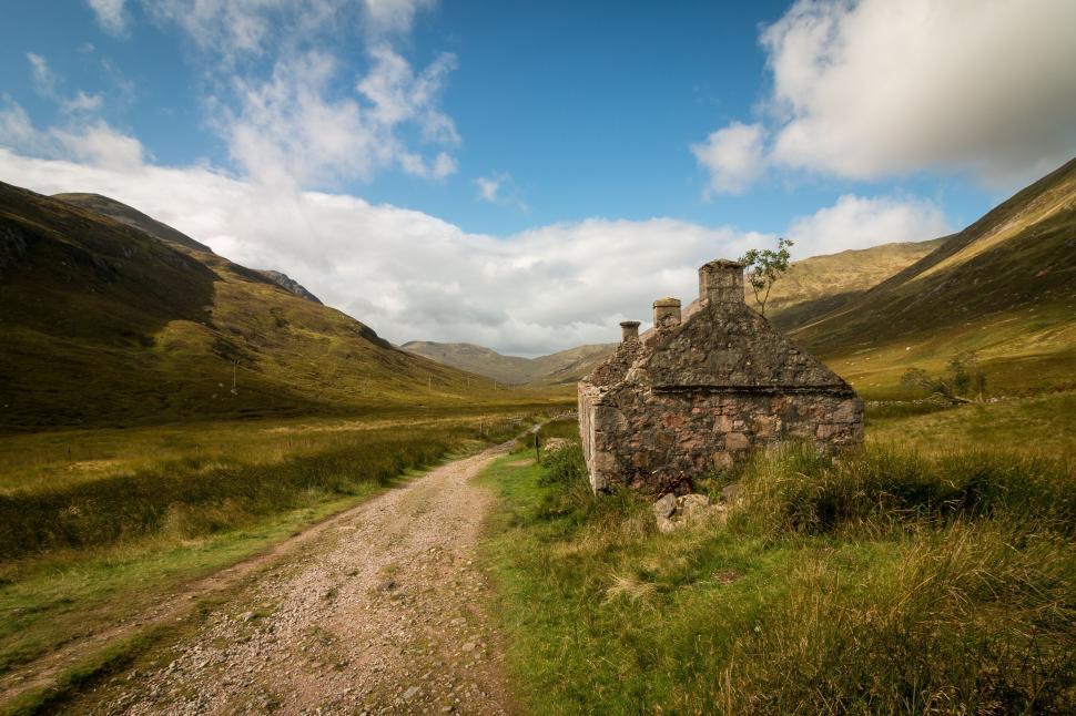 Free Image of A stone house in a grassy field 