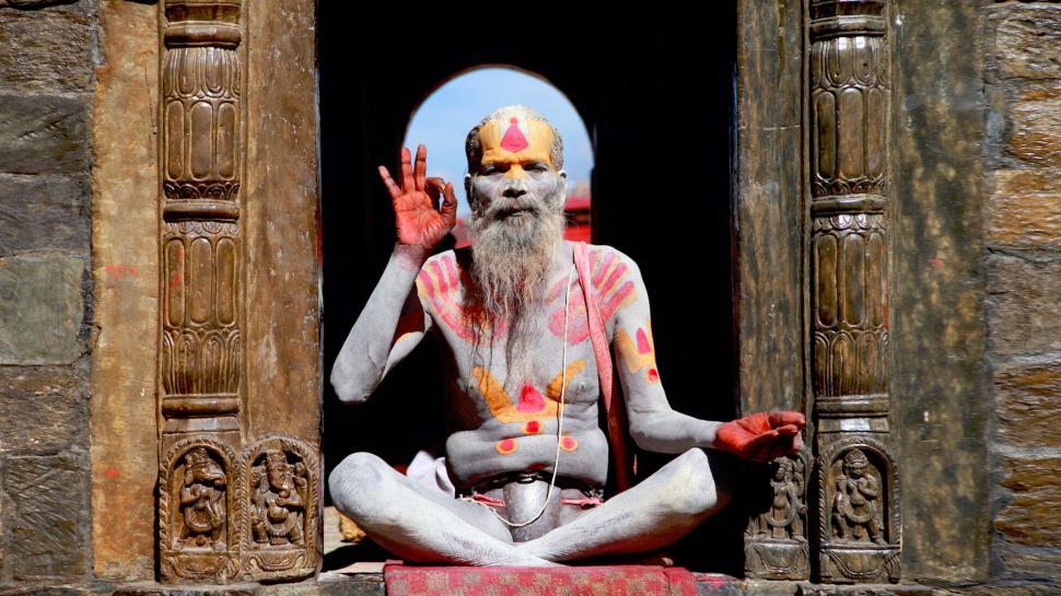Free Image of A man with a beard and painted face sitting in a doorway 