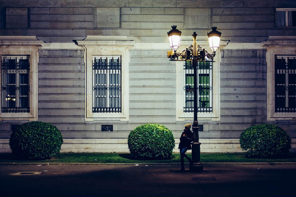 Free Image of A person standing next to a lamp post 