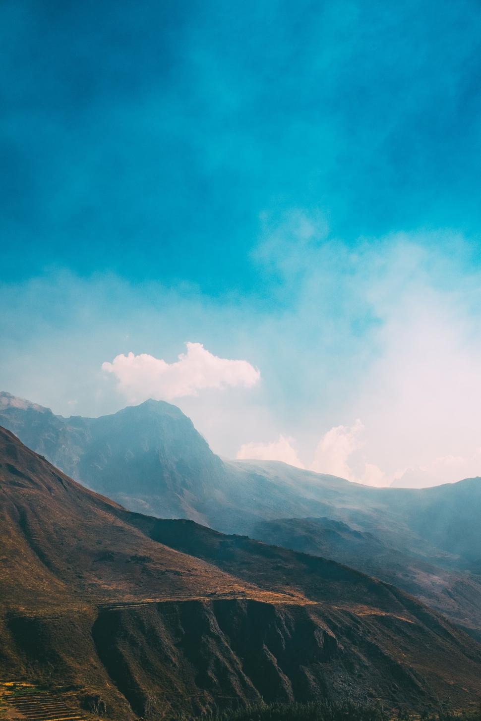 Free Image of A mountain range with clouds and blue sky 