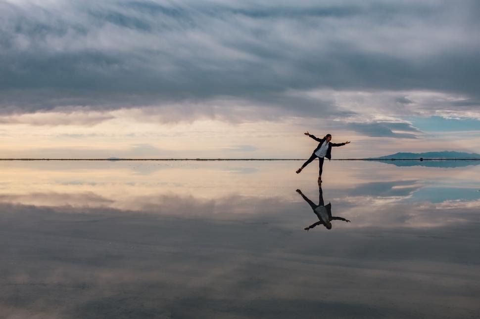 Free Image of A person standing on a surface with their arms outstretched 