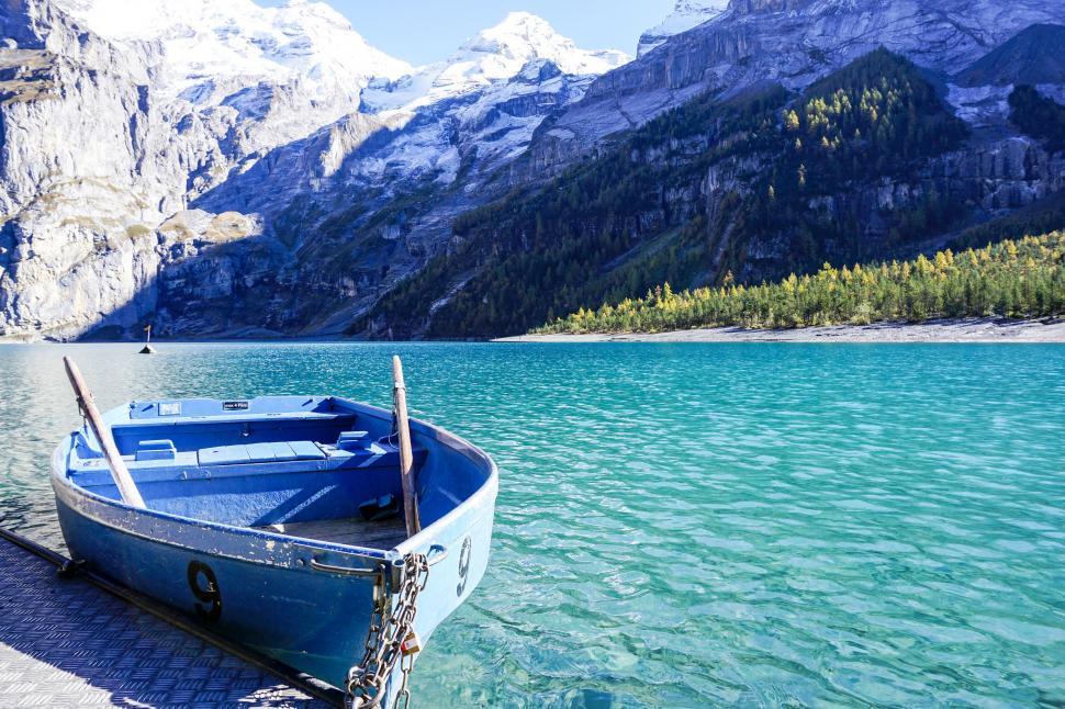 Free Image of A boat on a dock next to a body of water 
