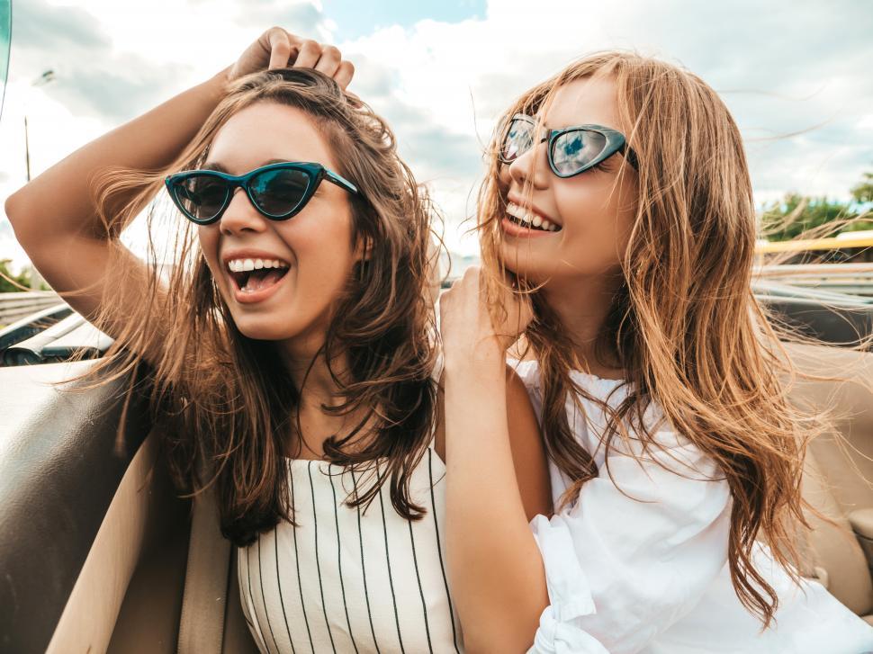 Free Image of Two women wearing sunglasses and smiling 