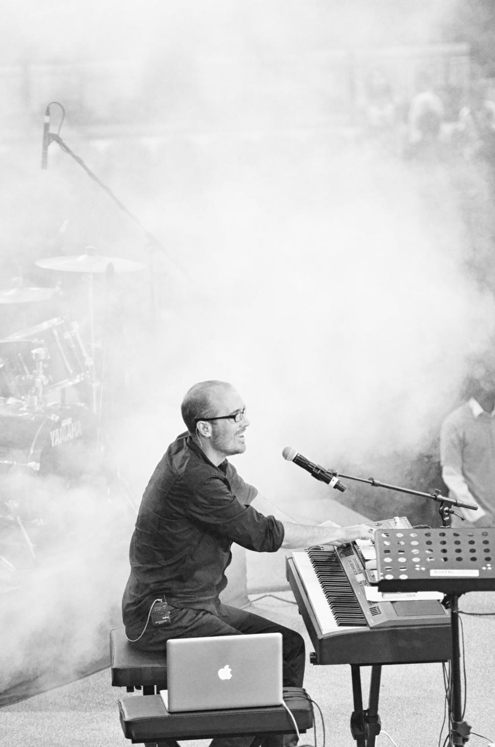 Free Image of A man sitting on a chair playing a piano 