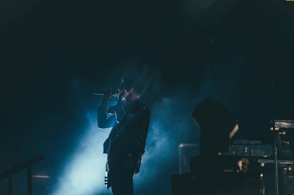 Free Image of A man singing into a microphone 