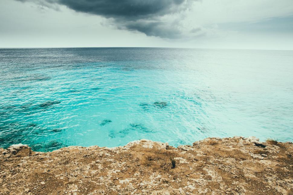 Free Image of A rocky cliff over a body of water 