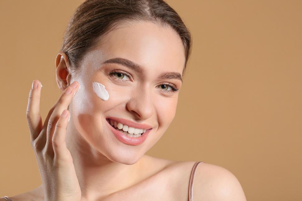 Free Image of A woman applying cream on her face 