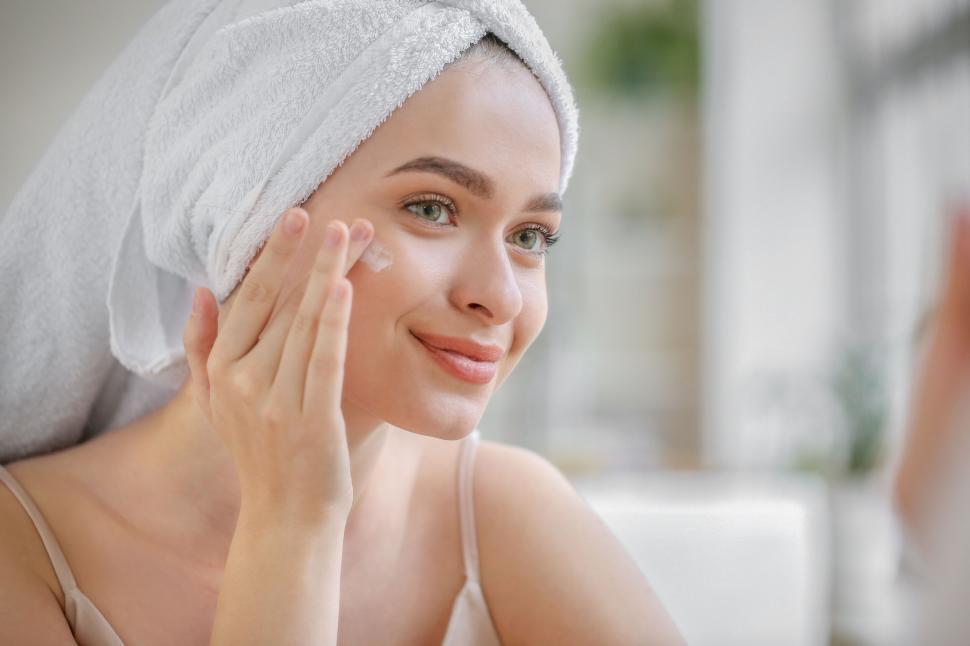 Free Image of A woman applying cream on her face 