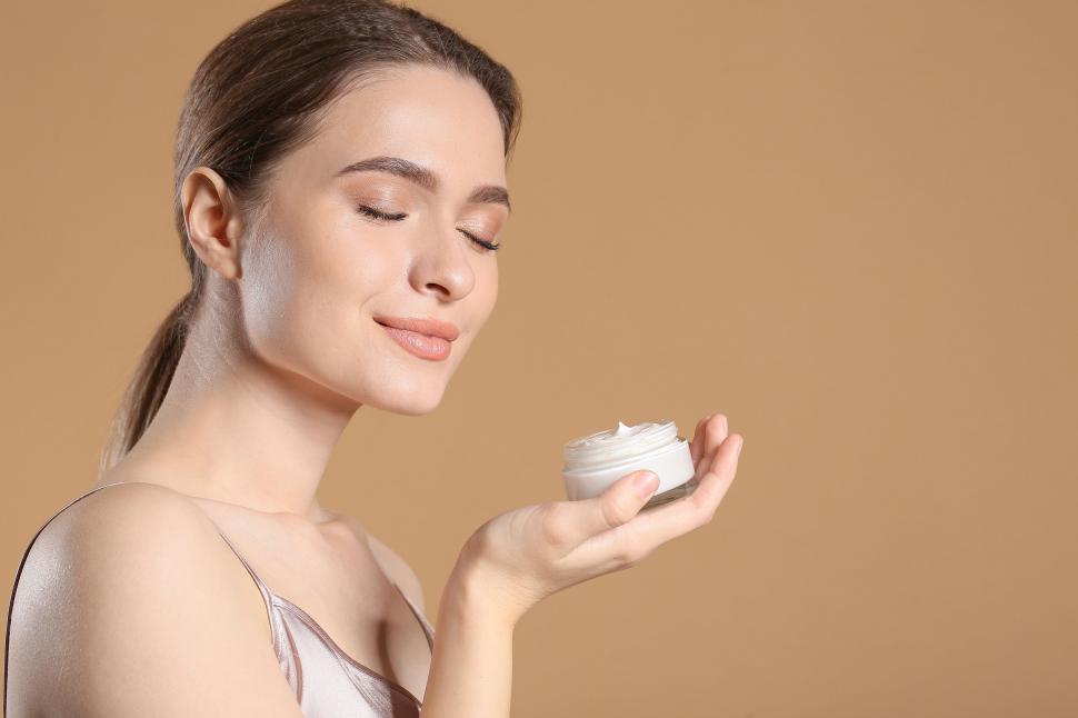 Free Image of A woman holding a jar of cream 