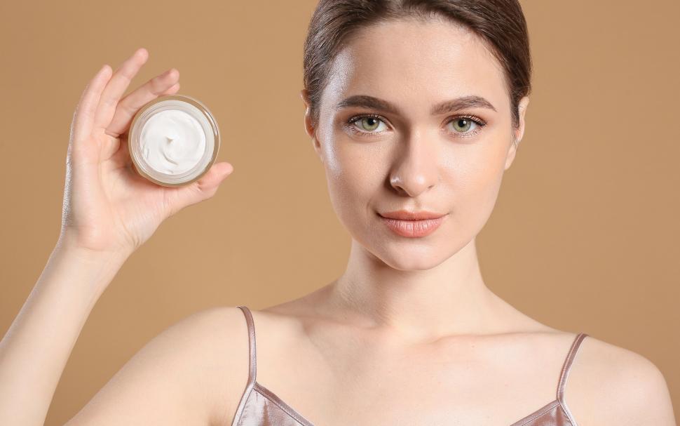 Free Image of A woman holding a jar of cream 