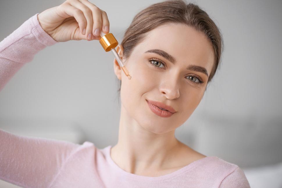 Free Image of A woman holding a dropper over her face 