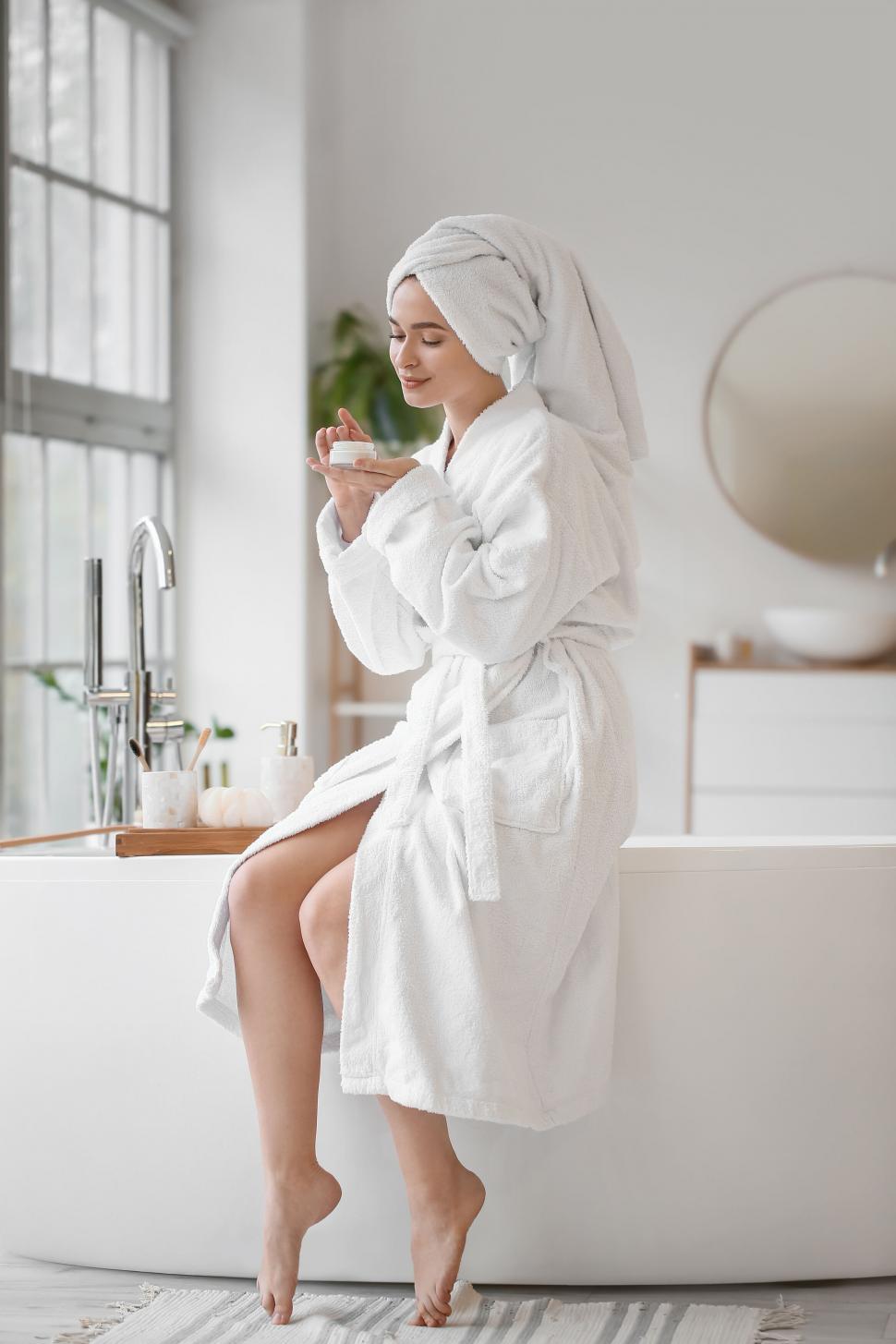 Free Image of A woman in a bathrobe and a towel on her head 