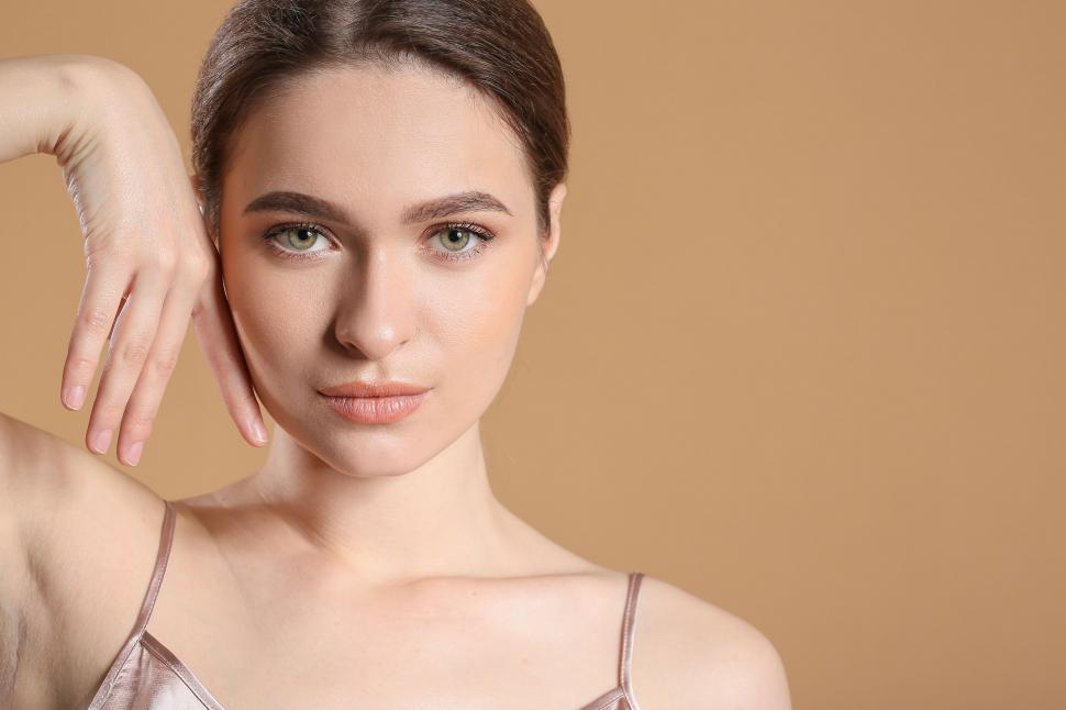 Free Image of A woman with green eyes and a hand on her face 