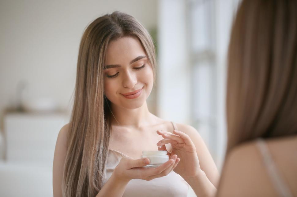 Free Image of A woman holding a jar of cream 