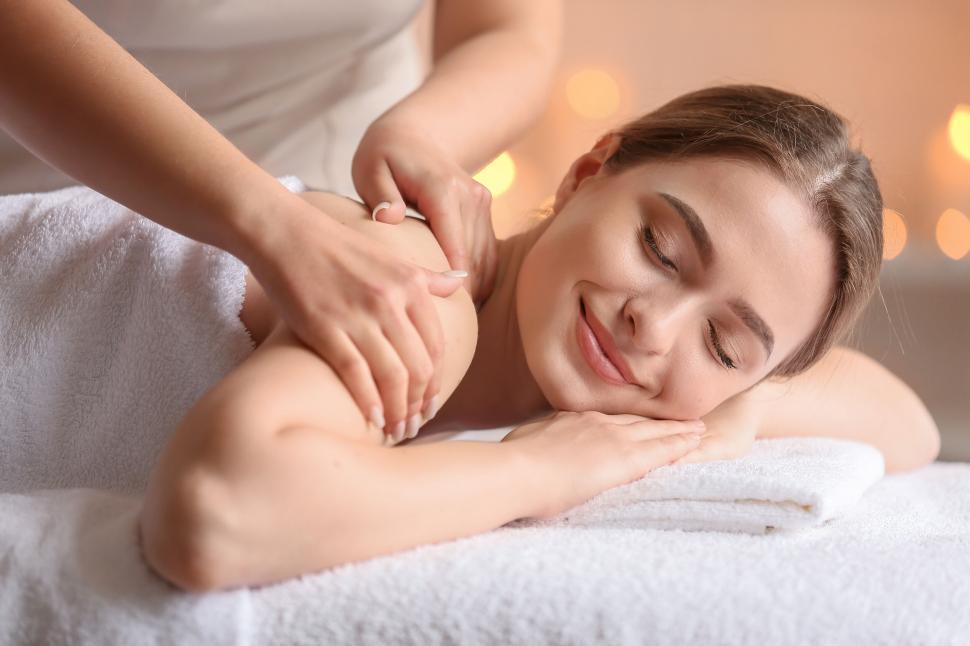 Free Image of A woman lying down on a white towel with her eyes closed 