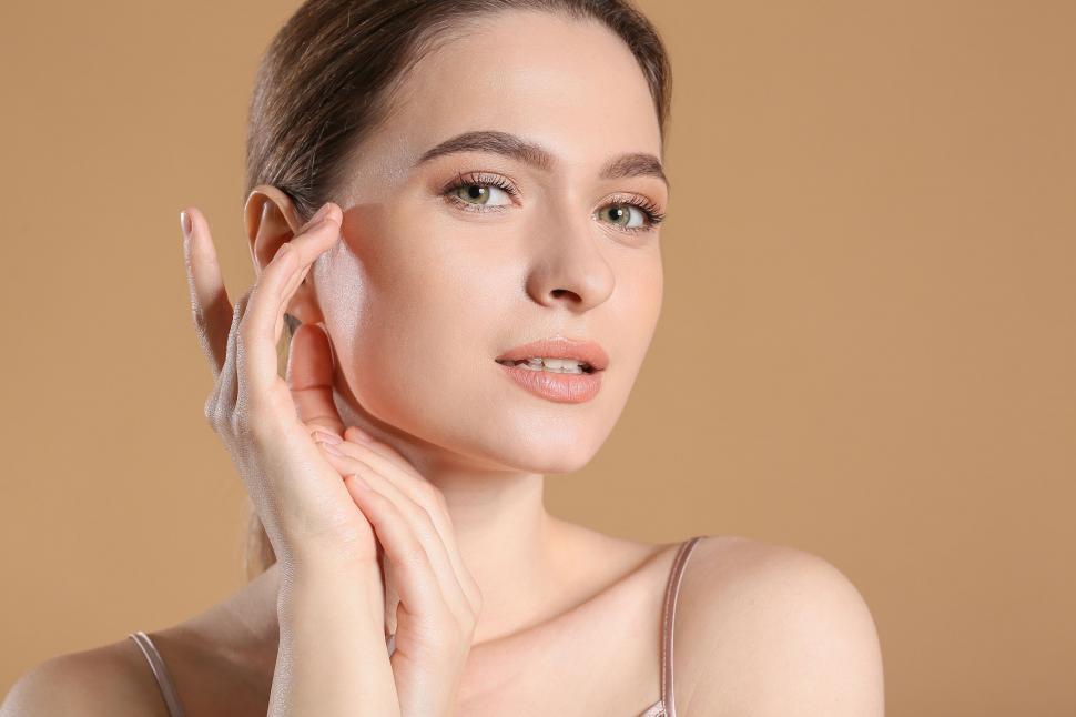 Free Image of A woman with wet skin touching her face 