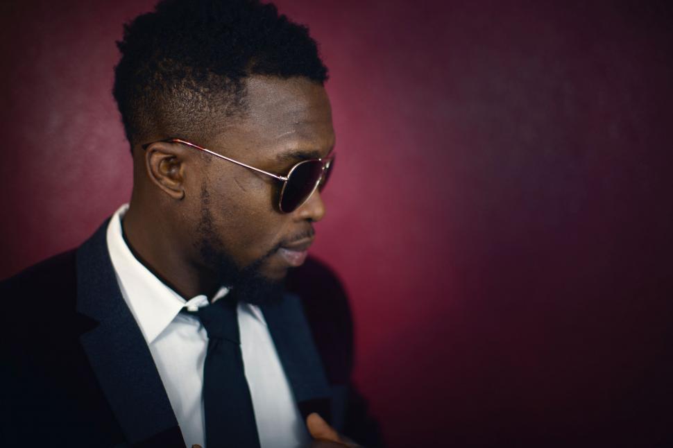 Free Image of A man wearing sunglasses and a suit 