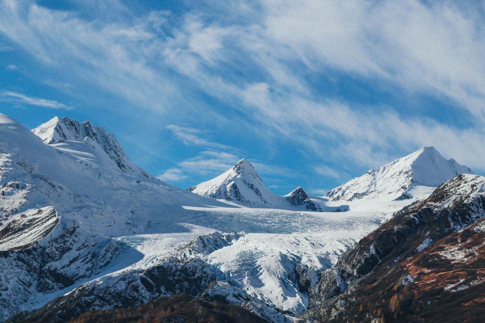 Free Image of Snow Covered Mountain Range Under Cloudy Blue Sky 
